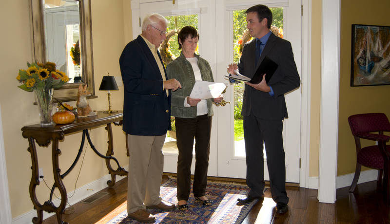 An open for inspection with a real estate agent and an older couple.