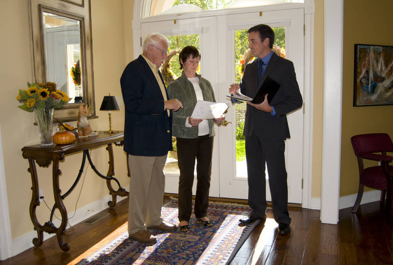 An open for inspection with a real estate agent and an older couple.