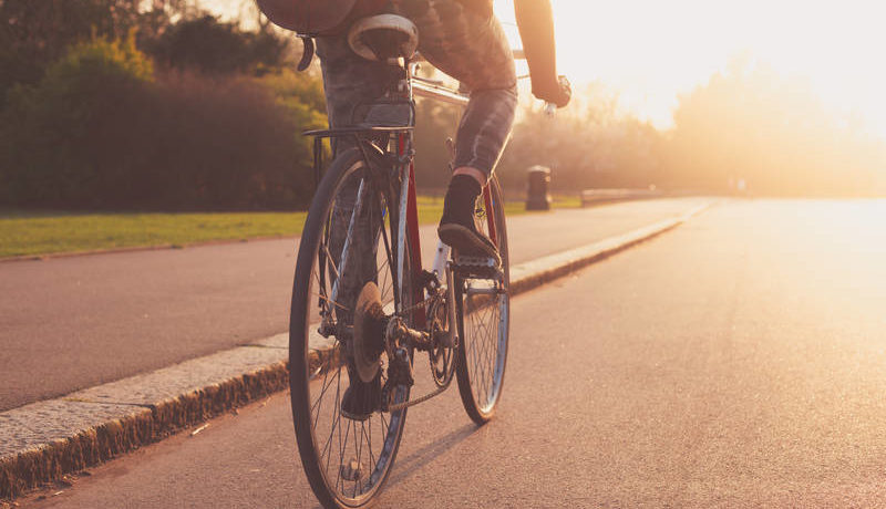 Riding a bike through a street at sunset