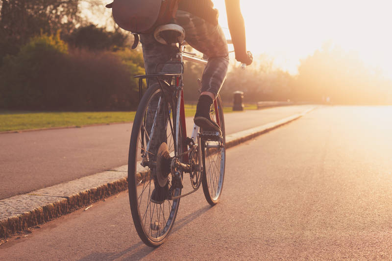 Riding a bike through a street at sunset